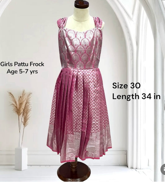 This Girls Pattu Frock in a rich pink & silver weave is crafted for little divas aged 5–7 yrs. A perfect blend of traditional Kanchi Pattu elegance with a frock-style charm