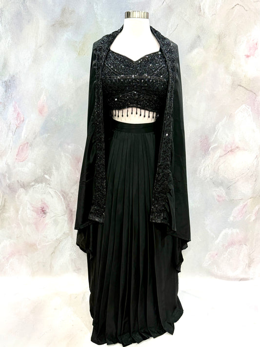 Black Crop Top Lehenga with an Elegant Jacket.Featuring intricate handwork on the crop top, a graceful flowing lehenga, and a chic long jacket that adds a touch of royal sophistication