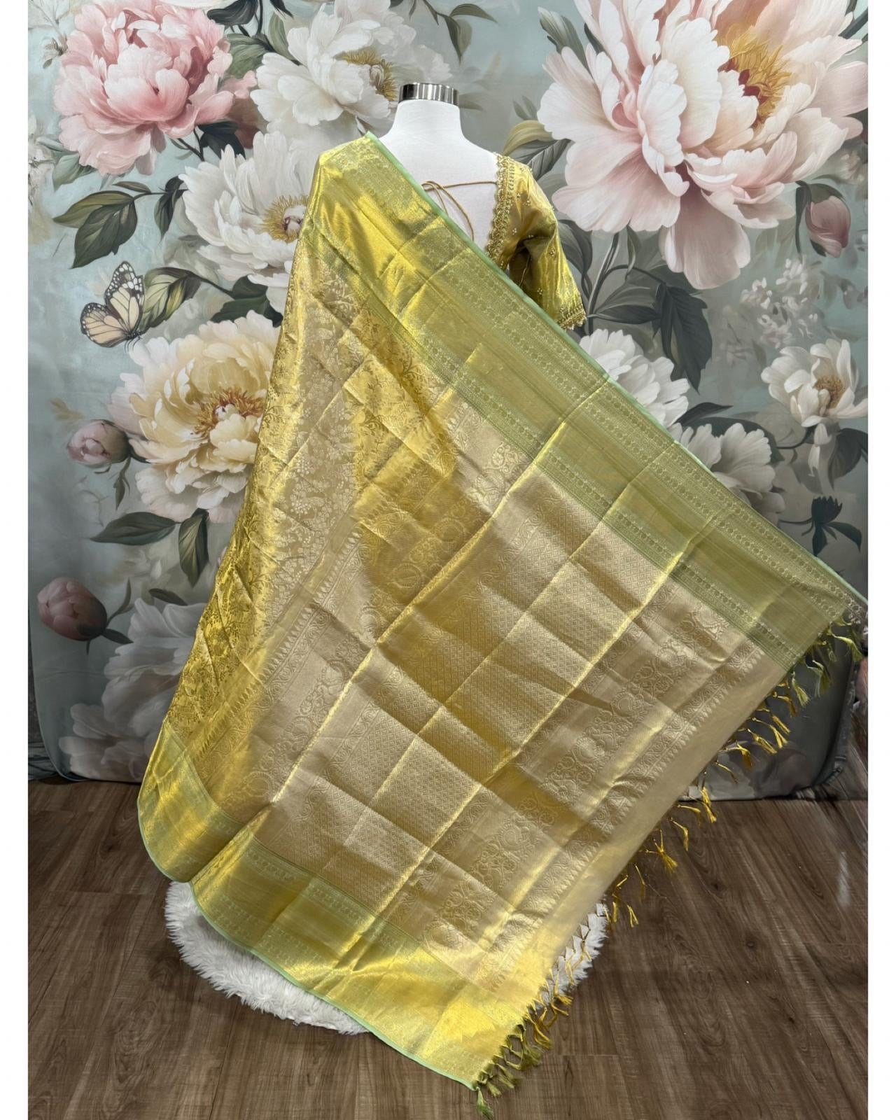 Pure Kanchi Pattu Silk mark certified Saree in shimmering gold with a subtle green border. Paired with an exquisite handcrafted Maggam work blouse. Available in size 40 to 44.