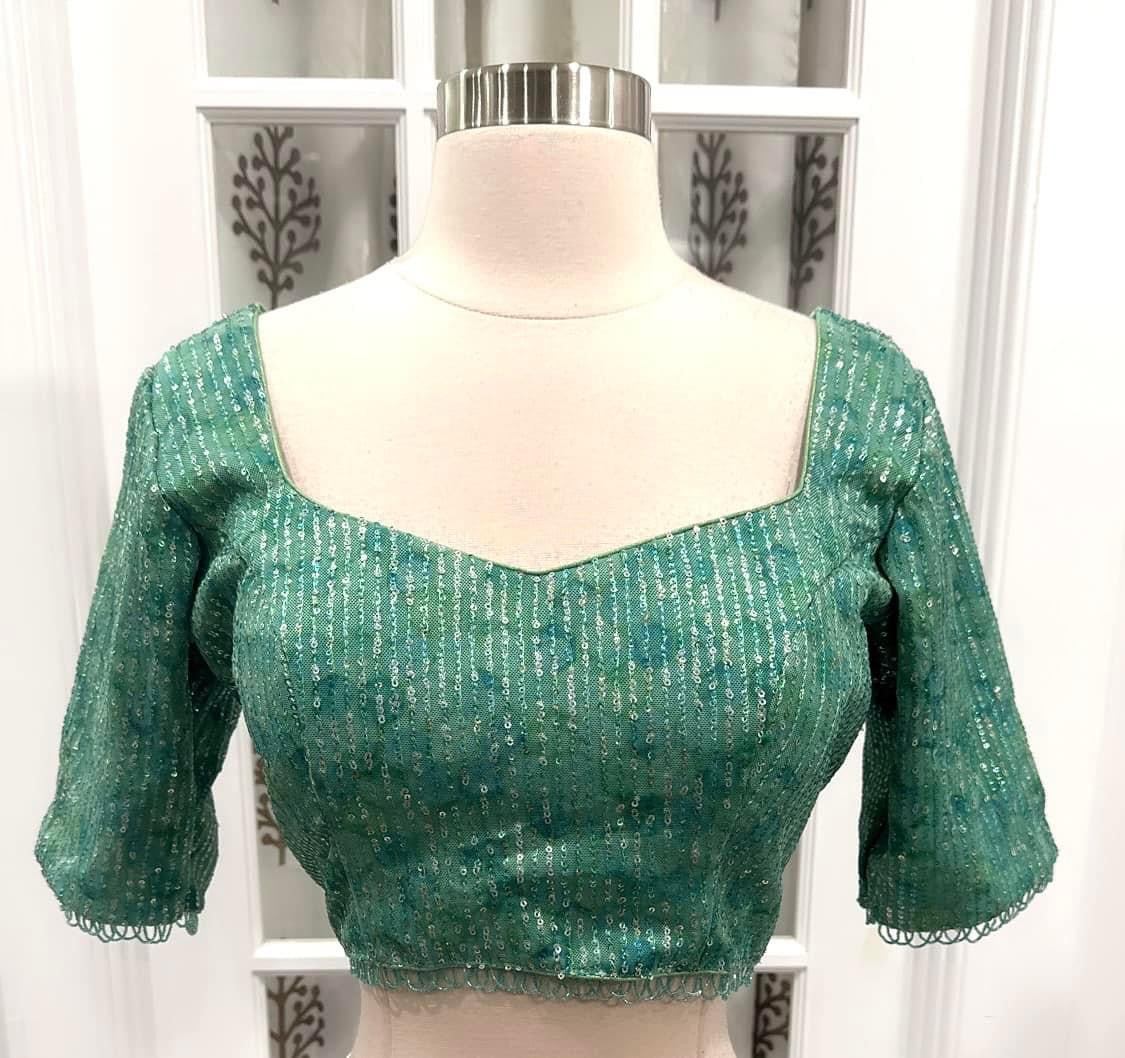 Dazzling partywear heavy sequin saree in silver grey and light green mint hues. Comes with a stitched blouse size 40 with bead embellishments
