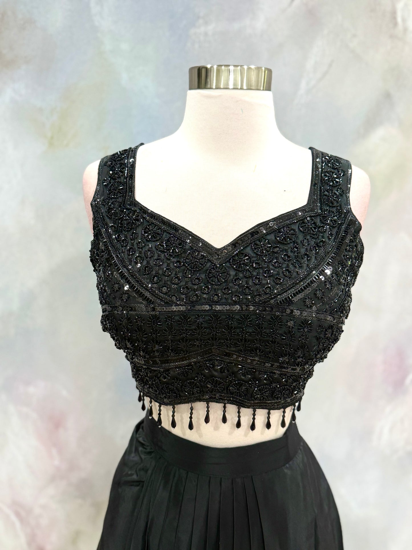 Black Crop Top Lehenga with an Elegant Jacket.Featuring intricate handwork on the crop top, a graceful flowing lehenga, and a chic long jacket that adds a touch of royal sophistication