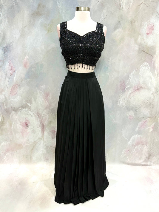 Black Crop Top Lehenga with an Elegant Jacket.Featuring intricate handwork on the crop top, a graceful flowing lehenga, and a chic long jacket that adds a touch of royal sophistication