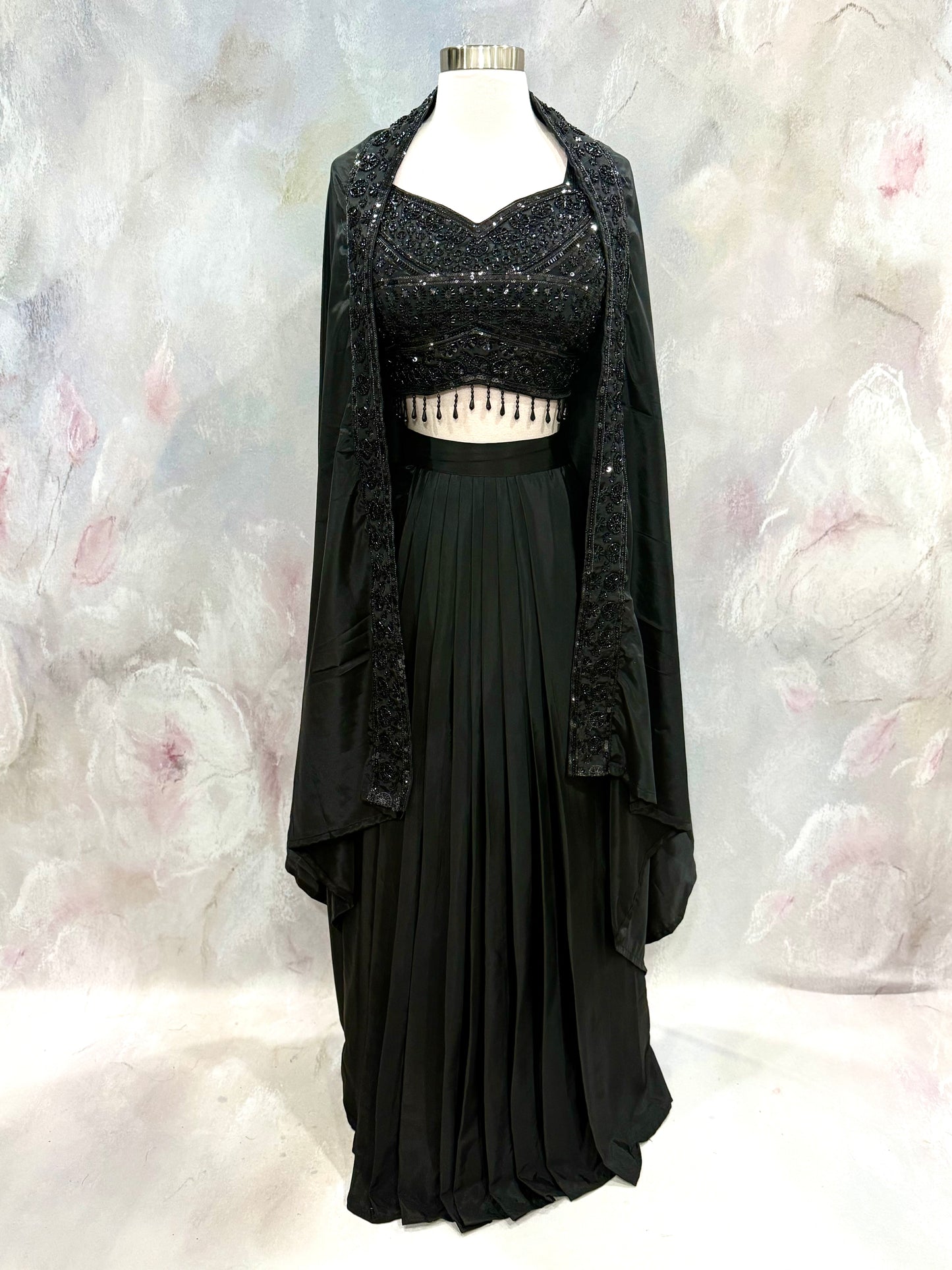Black Crop Top Lehenga with an Elegant Jacket.Featuring intricate handwork on the crop top, a graceful flowing lehenga, and a chic long jacket that adds a touch of royal sophistication