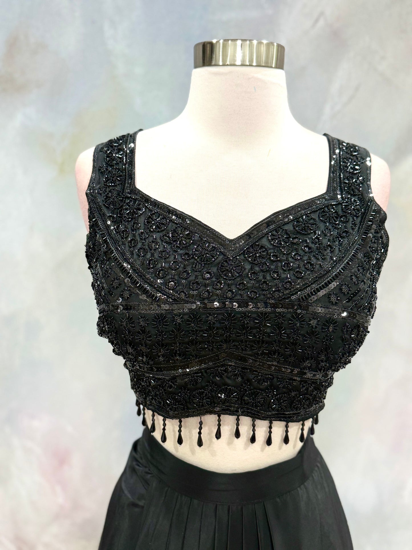 Black Crop Top Lehenga with an Elegant Jacket.Featuring intricate handwork on the crop top, a graceful flowing lehenga, and a chic long jacket that adds a touch of royal sophistication