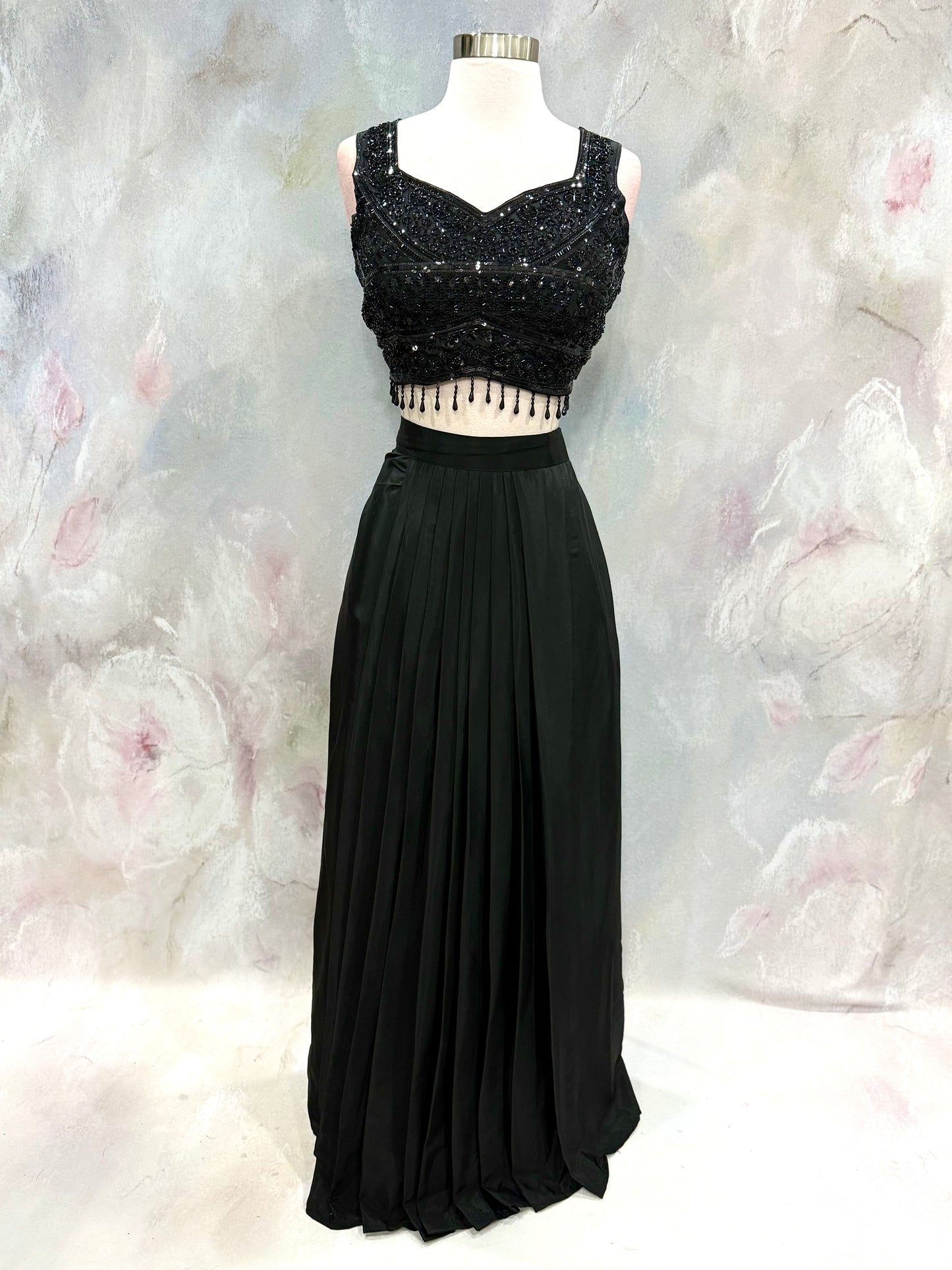 Black Crop Top Lehenga with an Elegant Jacket.Featuring intricate handwork on the crop top, a graceful flowing lehenga, and a chic long jacket that adds a touch of royal sophistication