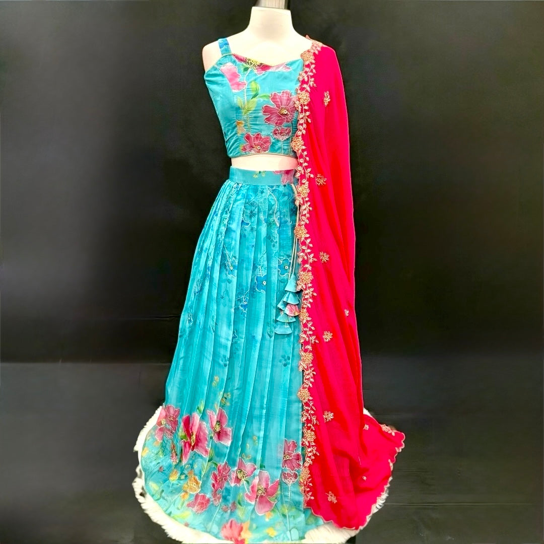 Turn heads with this stunning customized organza lehenga set. The vibrant turquoise blue lehenga with floral detailing pairs beautifully with a hot pink embroidered dupatta. Perfect for festive occasions, weddings. Available in size 34/36/38.