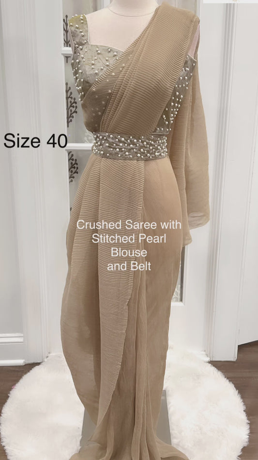 Elegance personified: The ethereal charm of a light taupe crushed saree paired with a pearl-embellished blouse